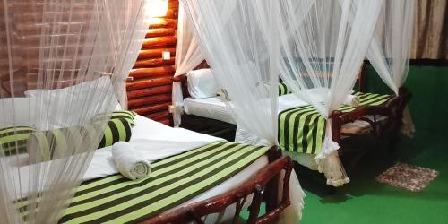 a bedroom with two beds with mosquito nets at Gotrika Valley Gesst in Ella