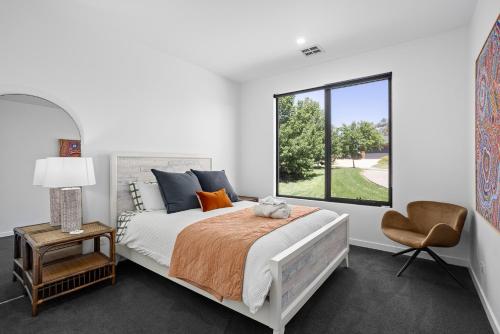 a white bedroom with a bed and a window at Wild Wombat in Mansfield