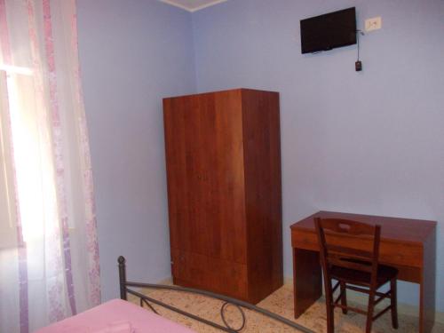 una camera da letto con scrivania e armadio in legno di B&B Porta di Suso Camerota a Camerota