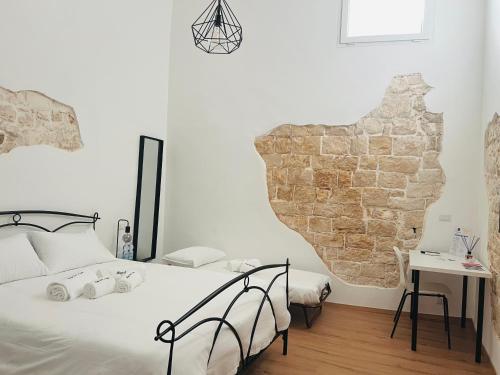 a bedroom with a bed and a brick wall at Borgo Sant' Angelo Exclusive House in Conversano