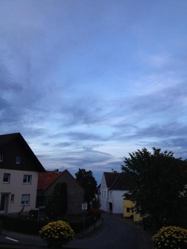 a town street with houses and a cloudy sky at Sauerland-Hotel in Essentho