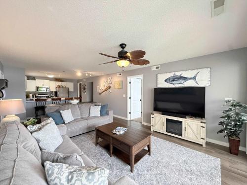 a living room with a couch and a flat screen tv at Lakefront Vibes Waterfront Pool in Osage Beach