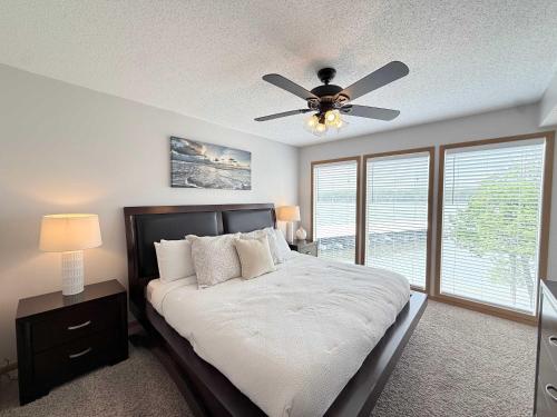 a bedroom with a bed with a ceiling fan at Lakefront Vibes Waterfront Pool in Osage Beach