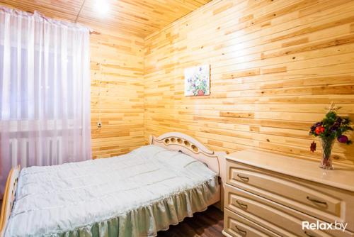 a bedroom with a bed and a wooden wall at Agrosadba Dubki in Apchak