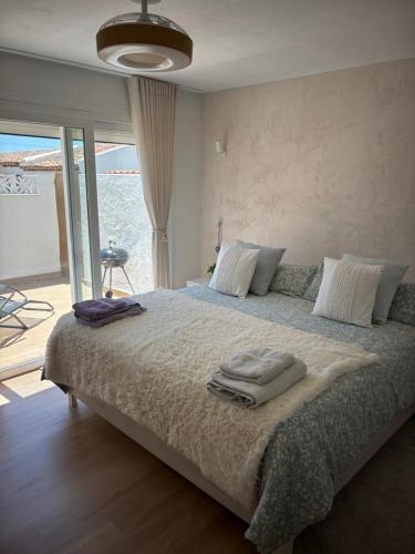 a bedroom with a large bed with towels on it at La Perla del Mar in Estepona