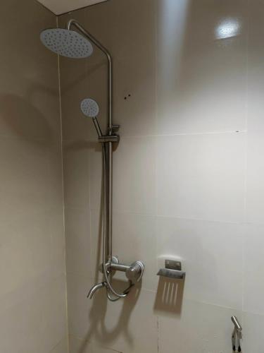 a shower in a bathroom with a shower head at Nice Hotel Aurora Cubao in Manila