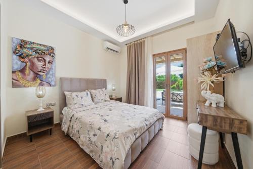 a bedroom with a bed and a television in it at Villa Astron in Agios Georgios