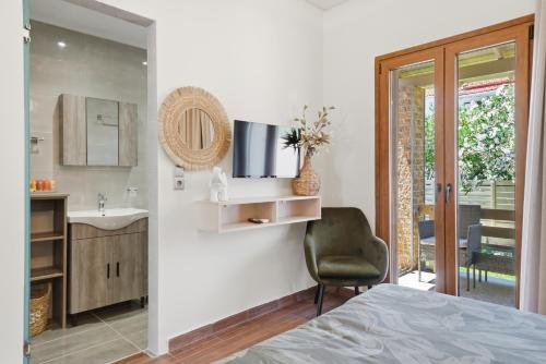 a bedroom with a bed and a sink and a mirror at Villa Astron in Agios Georgios