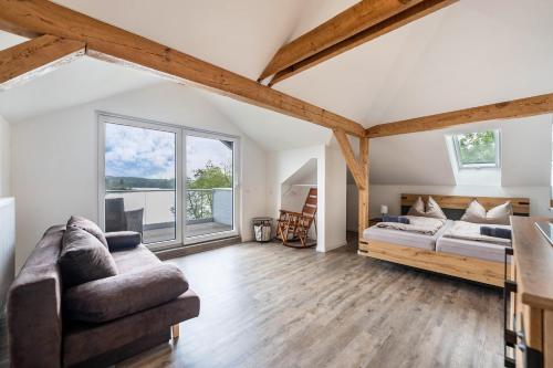 a living room with a bed and a couch at Haus am See in Stocksee