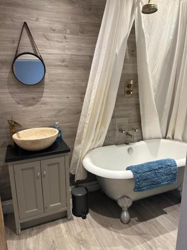 a bathroom with a bath tub and a sink at 3 or 4 Bed 2 Bath Cosy Rural Barn Conversion-Parking in Beoley