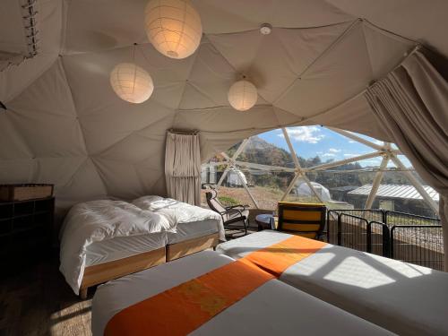 a bedroom with two beds in a tent at 里山グランピングむすび in Mizunami