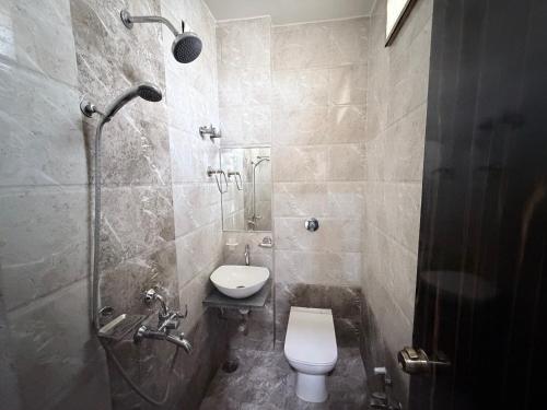 a bathroom with a toilet and a shower at Hotel SR Executive, Akola in Akola