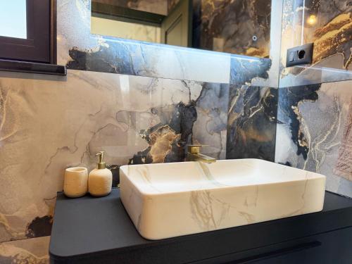 a bathroom with a sink and a marble wall at Villa Nella in Tinjan
