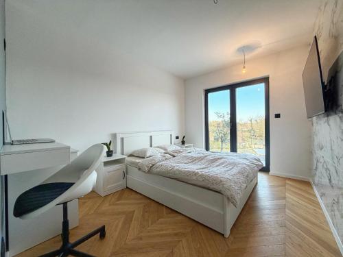 a white bedroom with a bed and a window at Villa Nella in Tinjan