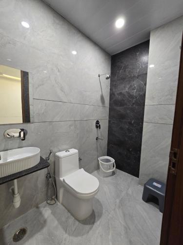a bathroom with a white toilet and a sink at Shree Radha Raman Sarkar Dham in Vrindāvan