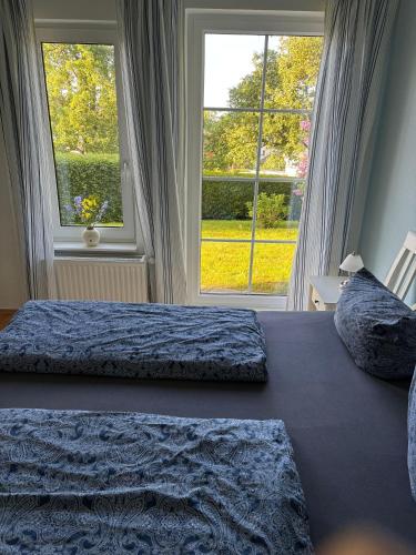 a bedroom with two beds and a large window at Ruhe-Natur-Meerblick-Das-Atelier-in-Lohme-Wandern-Radfahren-Golf-direkt-vor-der-Tuer in Lohme