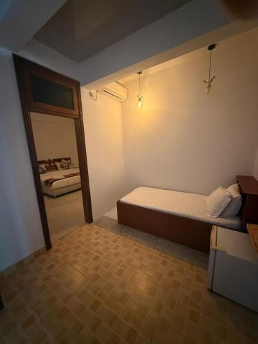a small bedroom with a bed and a mirror at Banana villa in Rasdhoo