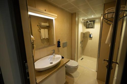 a bathroom with a sink and a toilet and a shower at Devin Otel in Isparta