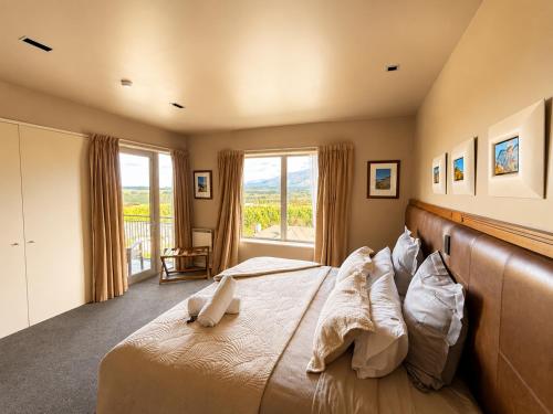 a bedroom with a large bed and a large window at Best high country retreat - Terrace Downs in Windwhistle
