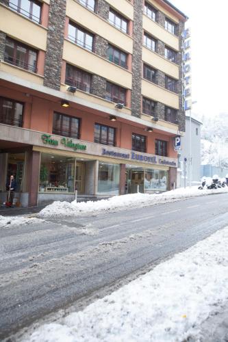 a snow covered street in front of a building at Insitu Eurotel Andorra in Andorra la Vella