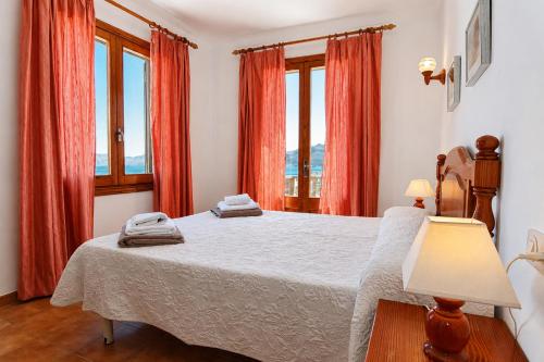 a bedroom with a large bed with red curtains at 045 Casa Embat ETV10796 by Mallorca Charme in Son Serra de Marina
