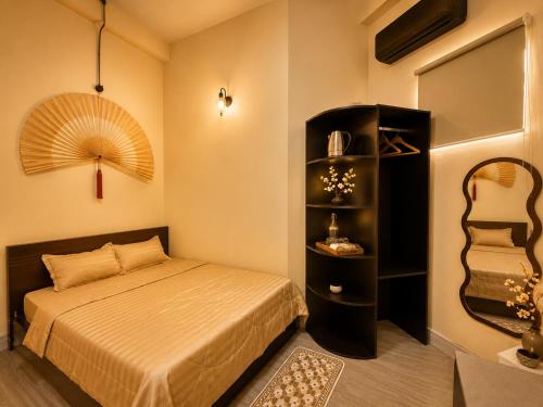 a bedroom with a bed and a shelf with a mirror at Spring Home 2 in Can Tho