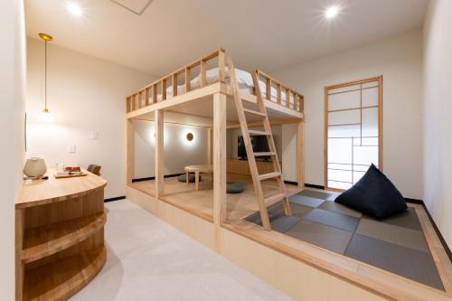 a room with a bunk bed and a desk at KITAMAE BASE Kaga Hashitate in Kaga