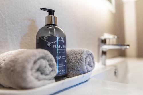 a bottle of soap and towels on a bathroom sink at Ferienwohnung Grubgut in Taxenbach