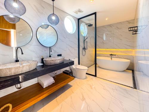 a bathroom with two sinks and a tub at Villa Exquisite Central Seminyak by Nagisa Bali in Seminyak