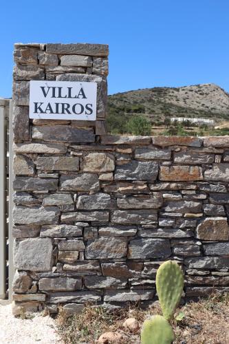 a sign on a stone wall with a cactus at Villa Kairos in Angairiá