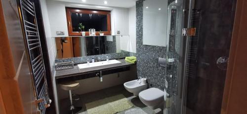 a bathroom with a sink and a toilet and a mirror at Apartmany Janosikove diery in Terchová