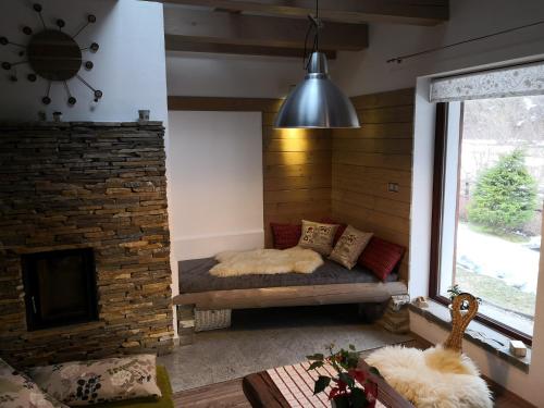 a room with a bed and a brick fireplace at Apartmany Janosikove diery in Terchová