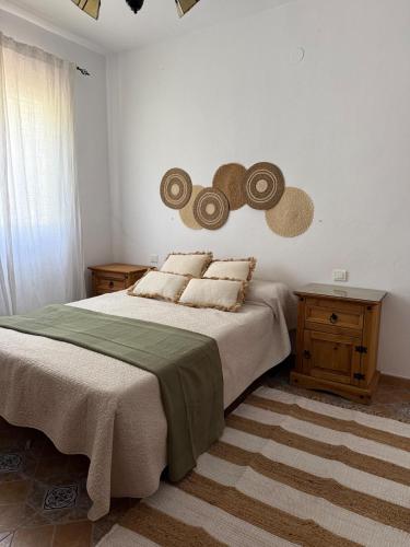 a bedroom with a large bed with hats on the wall at Casa Manila in Colmenar