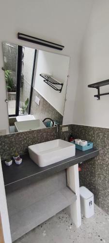 a bathroom with a sink and a mirror at Lokal Hotels Dauin in Dauin