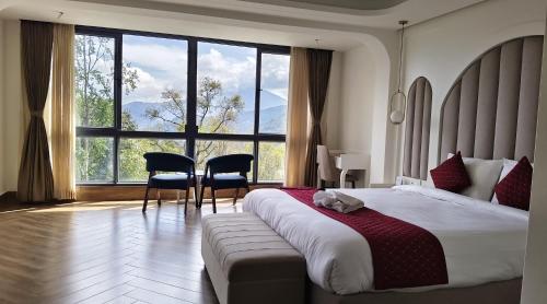 a bedroom with a large bed and a table and chairs at The Yasa Hotel In Gangtok in Gangtok