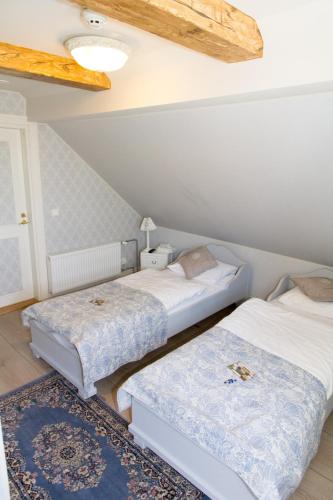 a bedroom with two beds and a rug at Vaihmalan Hovi in Lempäälä