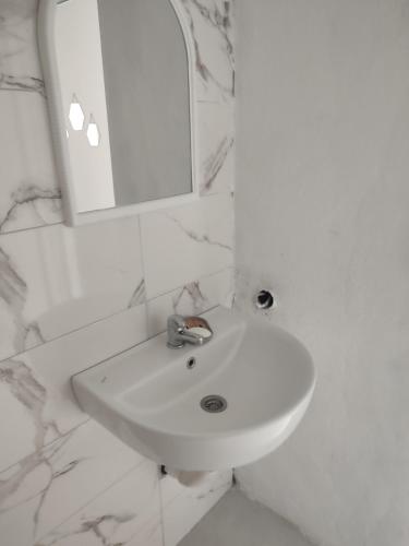 a white bathroom with a sink and a mirror at Dinos Apartments in Ulcinj