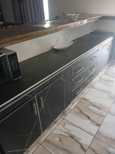 a kitchen with a black counter with a sink at Villa Ross in Saly Portudal