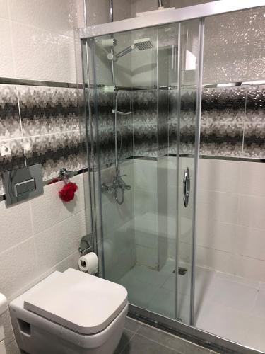 a bathroom with a glass shower with a toilet at Tk Residence in İzmir