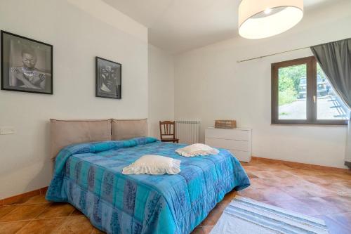 a bedroom with a bed with a blue blanket at Casa Orizzonte Anglona in Nulvi