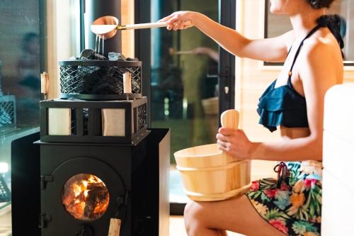 a woman is cooking in a wood stove at 郷音 ～G.O.A.T～ in Tsuru 