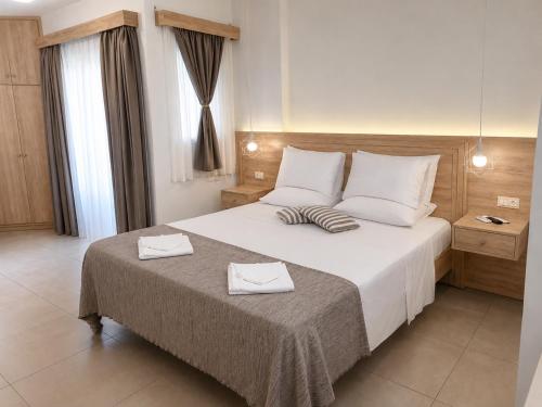 a bedroom with a large bed with two towels on it at Porfyris Studios and Apartments in Karpathos