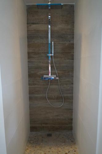une douche dans une salle de bain avec un mur en bois dans l'établissement Vacation Home - Maison de vacances, à Saint-Xandre