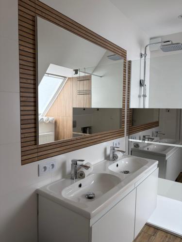 a bathroom with two sinks and a large mirror at Pensjonat Absynt in Nowy Targ