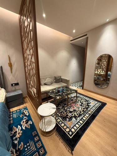 a living room with a couch and a table and a rug at THE MOONLIGHT STUDIo in Ghaziabad