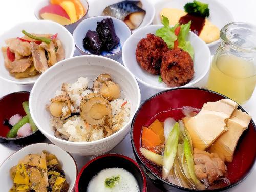 a table topped with bowls of different types of food at Dormy Inn Hirosaki in Hirosaki