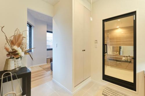 a hallway with a large glass door in a house at Préciosité Chigasaki プレシオジテ茅ヶ崎 in Chigasaki