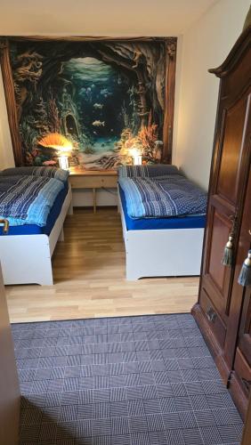 two beds in a room with a painting on the wall at aschis Lodge 2 in Soubey