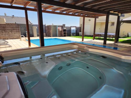 a hot tub in the middle of a swimming pool at חלום בהר- 2 סוויטות מפנקות עם בריכה ואמבט ספא במתחם in ‘Ein el Asad