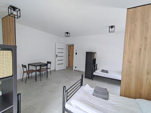 a room with a bed and a table and chairs at Apartamenty DK8 in Szalejów Górny